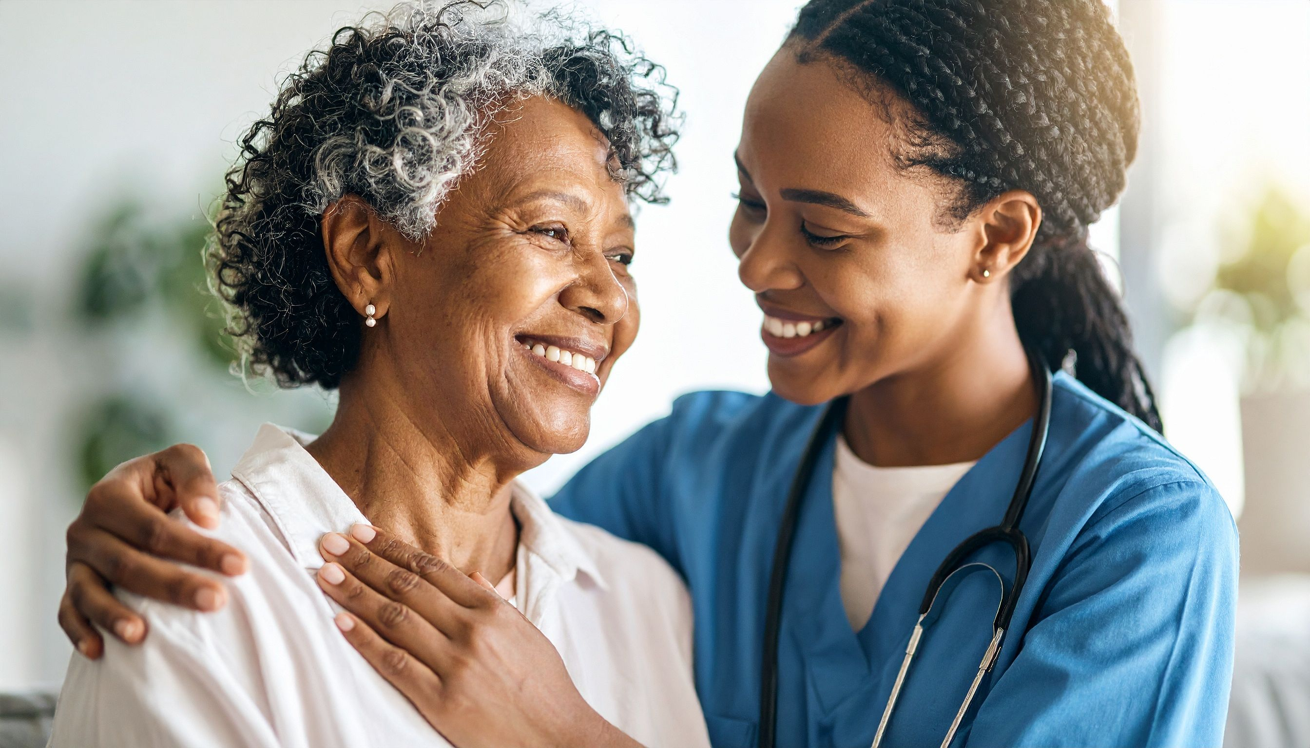 Smiling CareNow Africa caregiver supporting a family at home